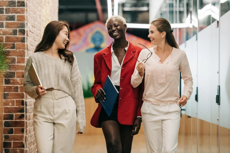 Geschäftsfrauen, die lächelnd im Büro spazieren gehen